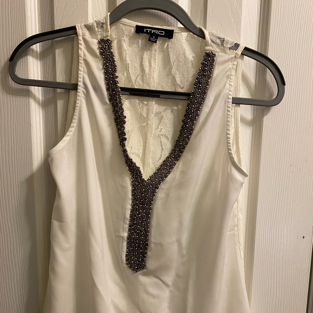 White sleeveless top with lace and bead accents